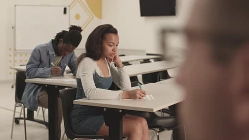 Unrecognizable Teacher Watching Students on Exam