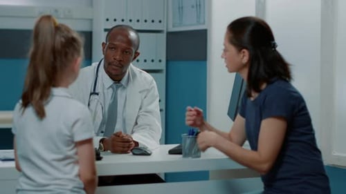 Doctor Consults with Mother and Child Patient