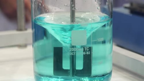 Liquid Being Mixed in a Beaker with Tool