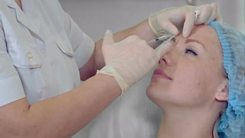 Professionelle Kosmetikerin macht Schönheitsspritzen an ihre Kundin Revitalisierung Anti-Aging