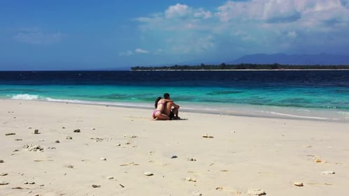 Young Man and Woman on Honeymoon Vacation Enjoy Luxury on Beach on Paradise White Sand