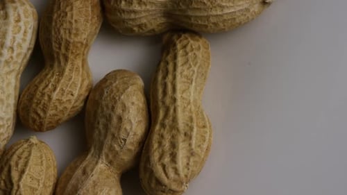 Cinematic, rotating shot of peanuts on a white surface - PEANUTS 005