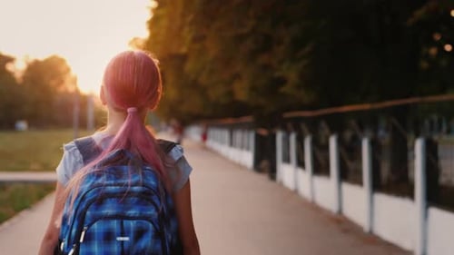 Mädchen mit Schultasche geht morgens zur Schule