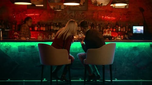 Ein bezauberndes Paar bei einem Date in der Bar - Barkeeper kommt zu ihnen
