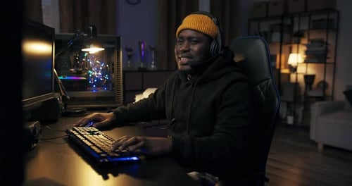 Young Adult Coding at Computer in Dark Room