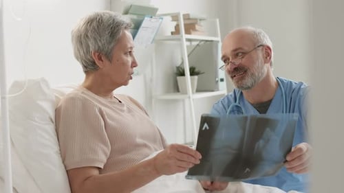 Aged Traumatologist Discussing X-ray Image with Patient