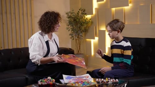 Therapist Discussing Artwork With a Boy on Couch