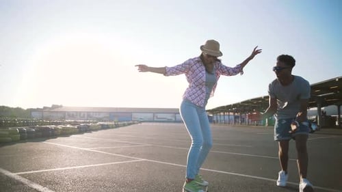 Young Attractive Mixed Race Couple Riding Skateboards and Having Fun Slow Motion
