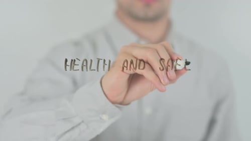 Hand Writes Health and Safety Message on Glass