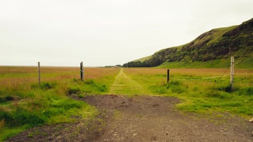 Flying Through Fence Posts Into Countryside Road Near Beautiful Icelandic Mountains.