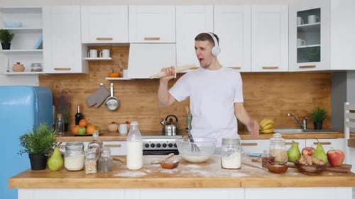 Young Man Singing in Kitchen with Rolling Pin