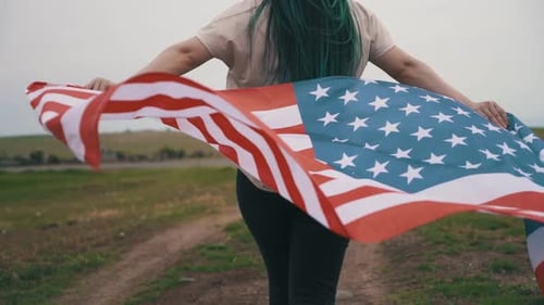 Subject Walking with American Flag in Rural Area