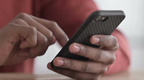 Hands Close up of African Man using Smartphone