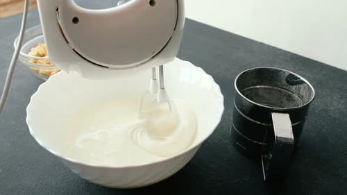 Electric Mixer Blending Sweet Ingredients in Bowl