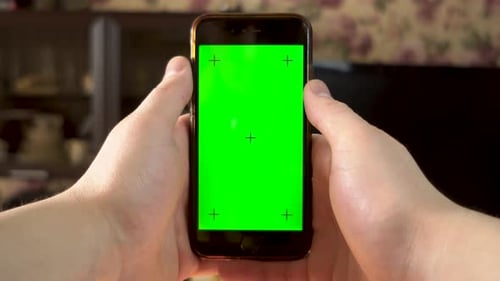 The Man Uses the Phone. Hand Makes a Finger Click on the Smartphone with a Green Screen. Chroma Key.