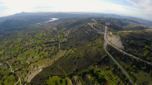 Camera Flying Above Majestic Green Hills With Olive Trees, Mountains on Horizon