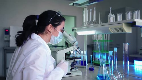 Woman in Lab Using Microscope for Research