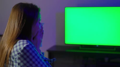 Woman Crying While Watching Television at Night