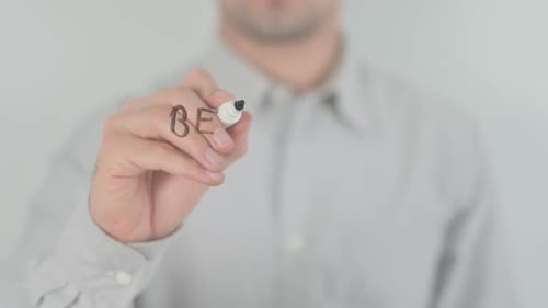 Man Writing Be Your Own Hero on Clear Surface