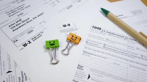 Tax Forms and Pen on Tabletop