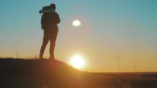 Lone Hiker Watching Scenic Sunset on Hilltop