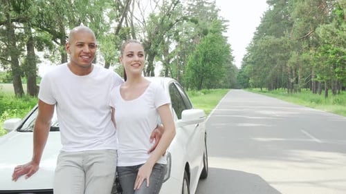 Smiling Couple Leaning Against Car on Country Road