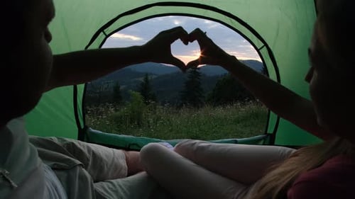 Couple in Tent Makes Heart with Hands, Sunset