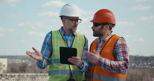 Ingeniero y técnico hablando en la azotea
