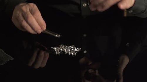 Hands Arrange Small Glass Pieces with Tweezers