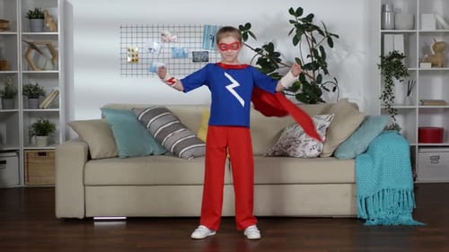 Child Dressed in Superhero Costume Standing at Home