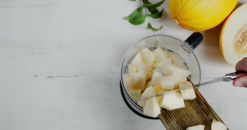 Les
tranches de melon sont placées avec une planche à découper dans le mélangeur.