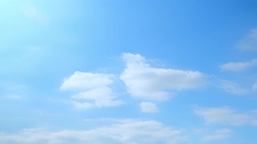 White Clouds Drifting Across Blue Sky Time-Lapse