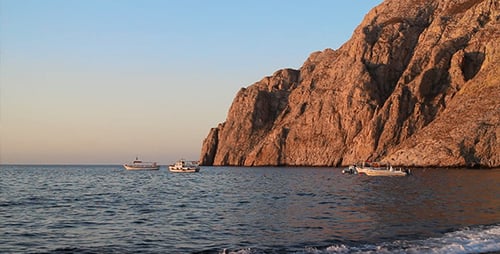 Boats Resting Near Mountain at Sunrise on Coast