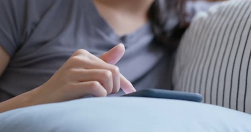 Adult Using Smartphone While Resting on Couch