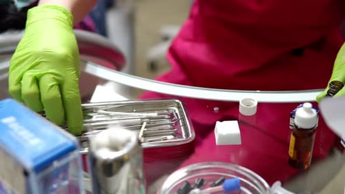 Nahaufnahme von Frauenhänden in Handschuhen bei der Zubereitung von Medikamenten und Ressourcen für die Zahnbehandlung