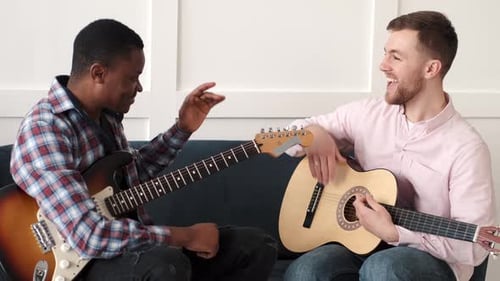 Two Friends Play Guitar Together