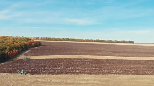 An Autumn Landscape of Fields and Sky - Tractors Plows the Field