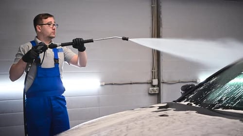 Worker at Car Wash Shop, Using Pressure Washer on Car, Man Washing Car with Compression Water.