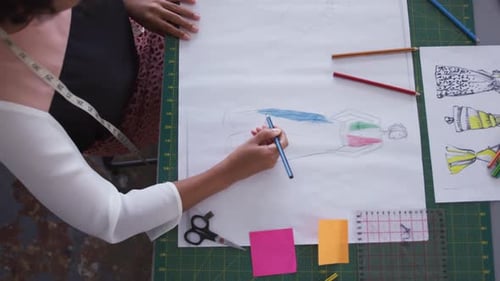 Mixed race woman drawing in fashion office