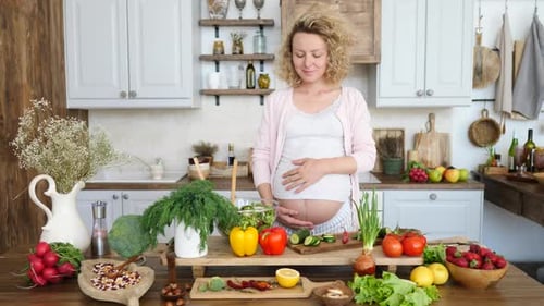 Pregnant Woman with Fruits and Vegetables in Kitchen