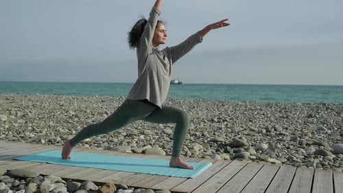 Frau macht Yoga an der Küste.