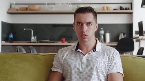Man Sitting on Couch Yelling