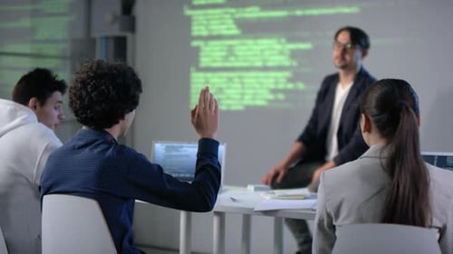Male Student Raising Hand At IT Class