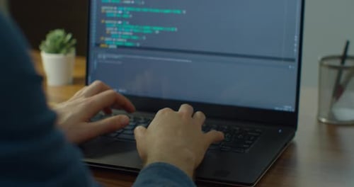 De cerca: ingenieros desarrollan una Aplicación de software utilizando un ordenador portátil digital que escribe el código en la pantalla