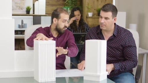 Architects Collaborate on Building Project in Office