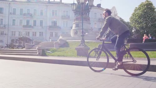 Cyclist Man Riding Fixed Gear Sport Bike in Sunny Day on a City