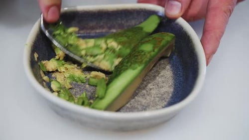 Mashing Avocado with a Spoon in Bowl