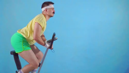 Man Rides Exercise Bike, Pumps Fist