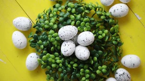 Green Decorative Easter Quail Eggs Wreath on Yellow Wooden Table