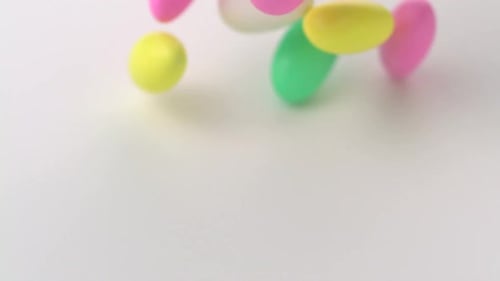 Colorful Easter Candies Falling onto White Surface